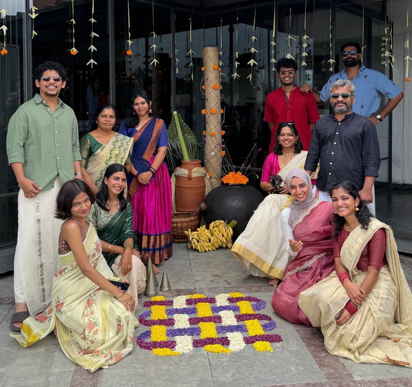 The btl team gathered at the studio beside a floral arrangement.
